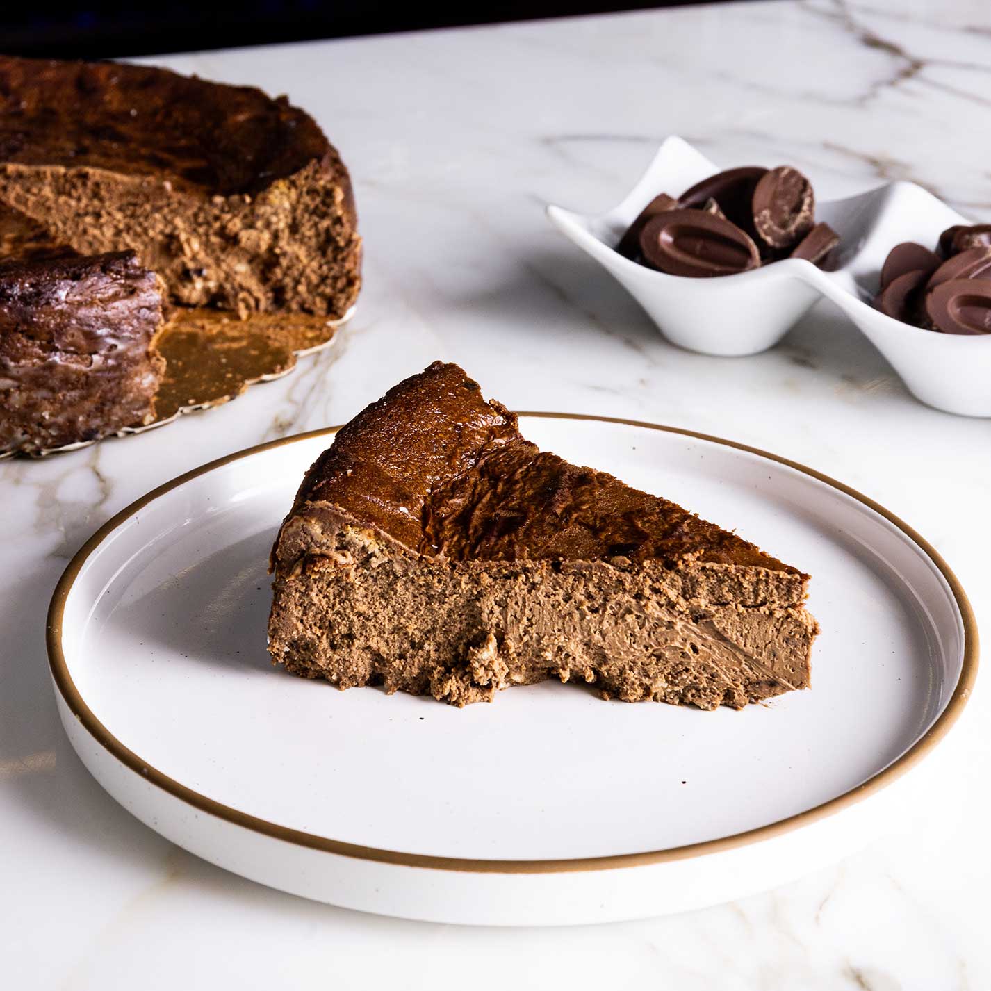 A slice of Chèvre Chocolate Basque Cheesecake, the whole cake as well as the chocolates.